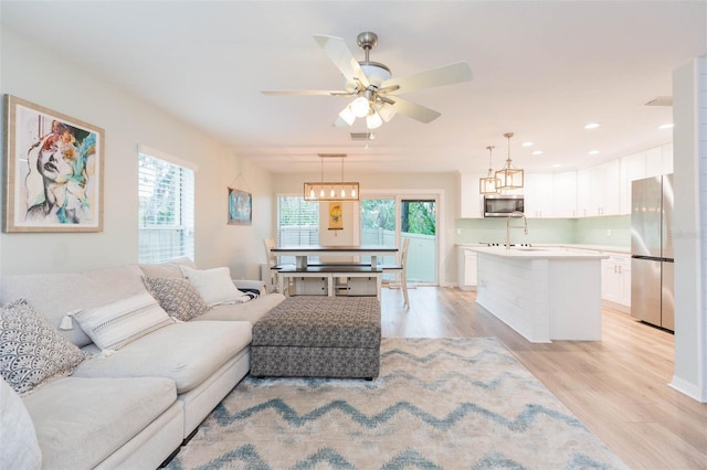 living area featuring visible vents, recessed lighting, a ceiling fan, and light wood-style floors