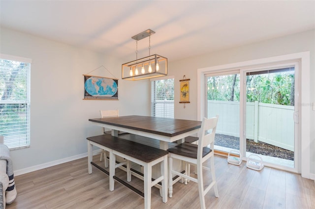 dining room featuring light wood-style flooring and baseboards