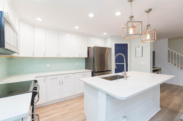 kitchen featuring light wood-style flooring, a sink, white cabinetry, light countertops, and appliances with stainless steel finishes