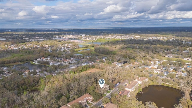 drone / aerial view featuring a water view and a wooded view