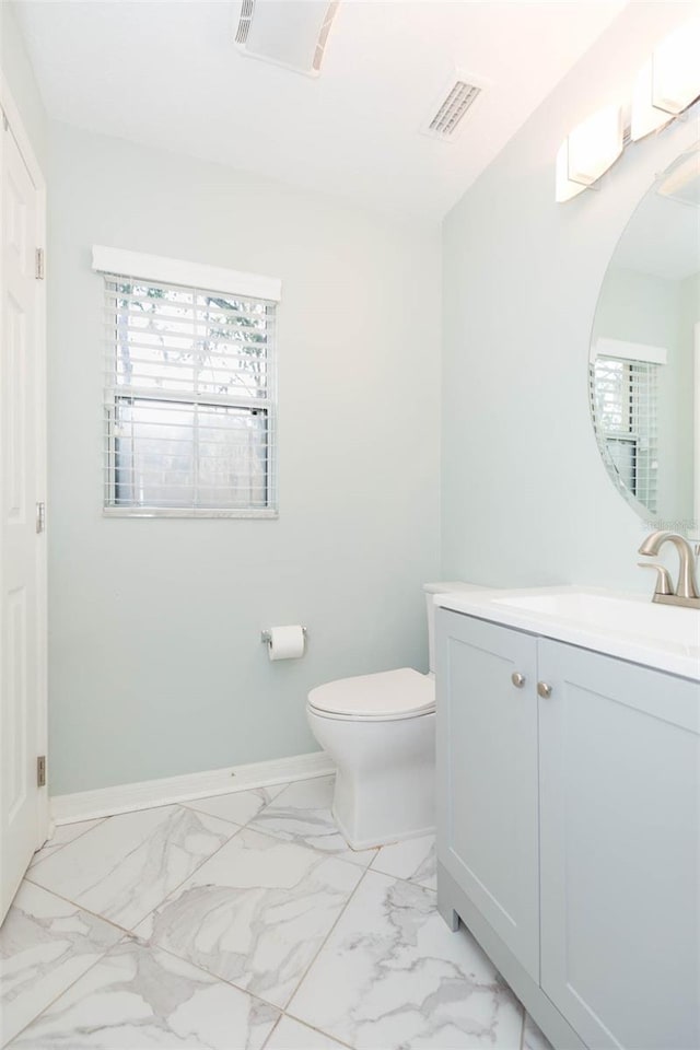 bathroom featuring marble finish floor, a healthy amount of sunlight, visible vents, and baseboards