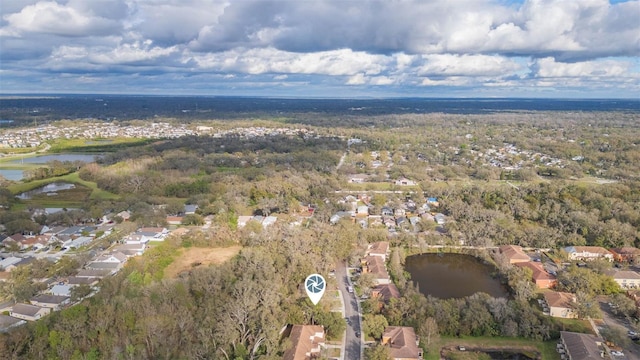 drone / aerial view with a water view, a residential view, and a wooded view