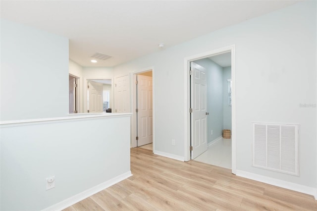 interior space with light wood-type flooring, visible vents, and baseboards