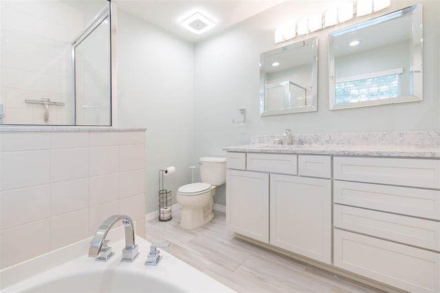 bathroom featuring a garden tub, toilet, vanity, baseboards, and a tile shower