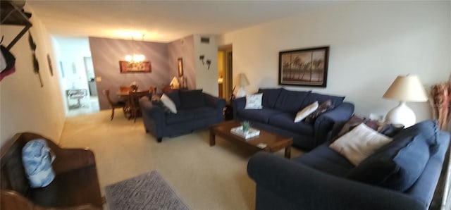 carpeted living room with an inviting chandelier