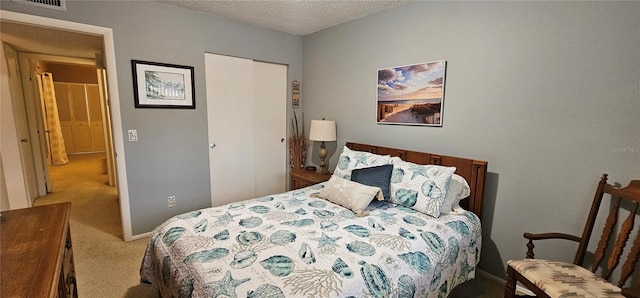 carpeted bedroom featuring a closet, visible vents, a textured ceiling, and baseboards