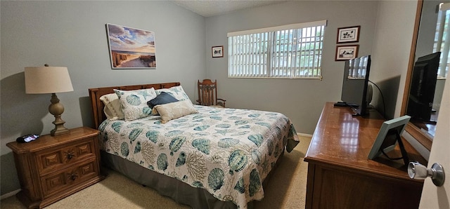 bedroom featuring light colored carpet and a textured ceiling