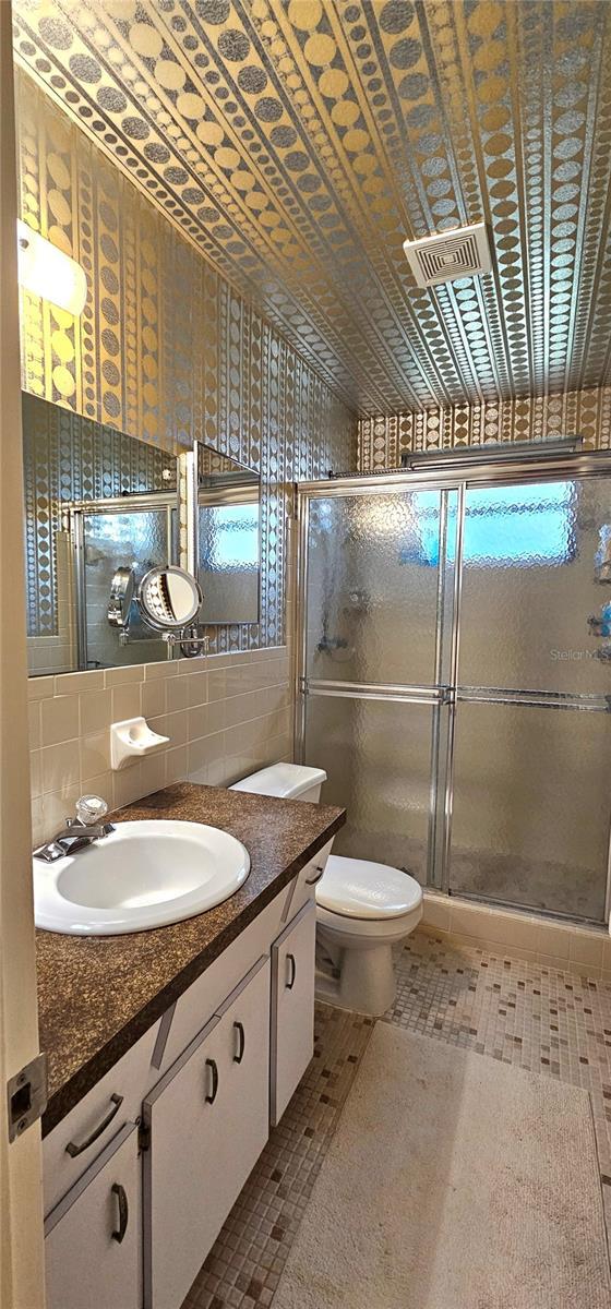 full bathroom with a stall shower, vanity, and decorative backsplash