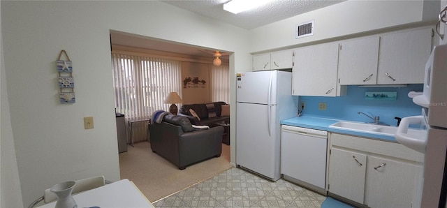 kitchen with white appliances, a sink, visible vents, light countertops, and light floors