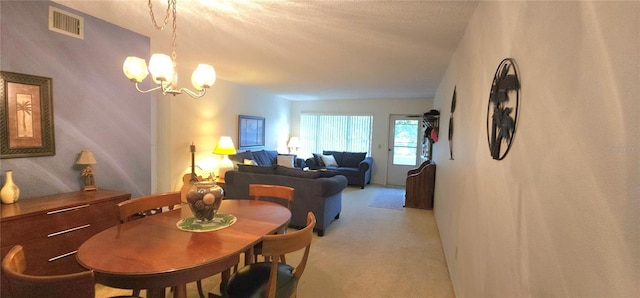 dining area featuring a chandelier, visible vents, and light colored carpet