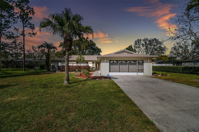 view of front facade with an attached garage, driveway, a front lawn, and stucco siding