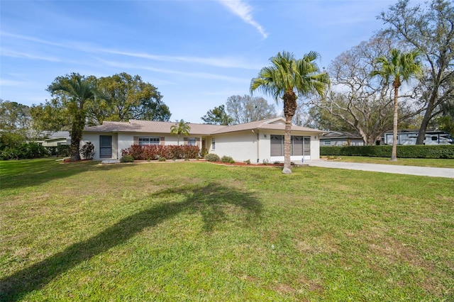 single story home featuring a garage, a front lawn, concrete driveway, and stucco siding