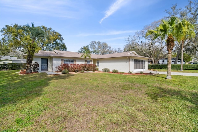 single story home featuring driveway, a front lawn, an attached garage, and stucco siding