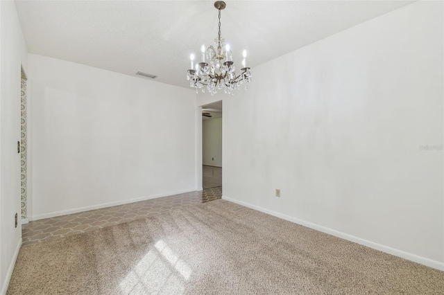 unfurnished room featuring carpet, visible vents, a chandelier, and baseboards