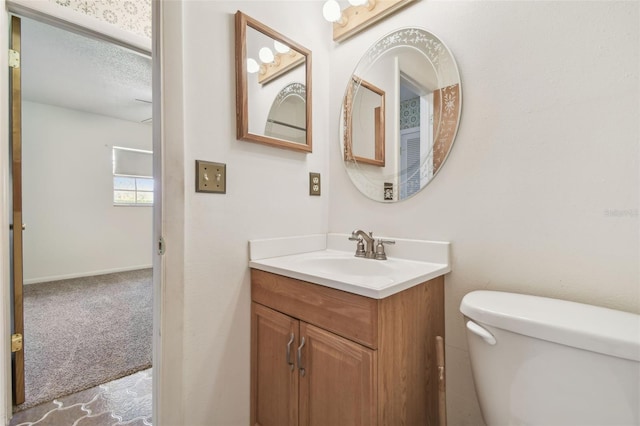 bathroom featuring vanity, toilet, and baseboards