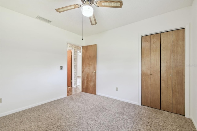 unfurnished bedroom with a closet, visible vents, carpet flooring, ceiling fan, and baseboards