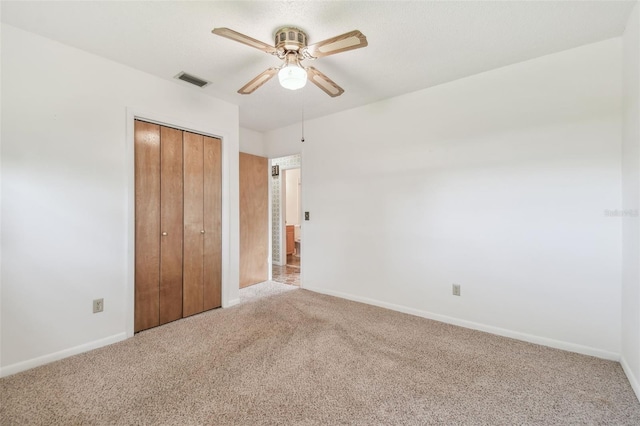 unfurnished bedroom with carpet floors, a ceiling fan, visible vents, baseboards, and a closet