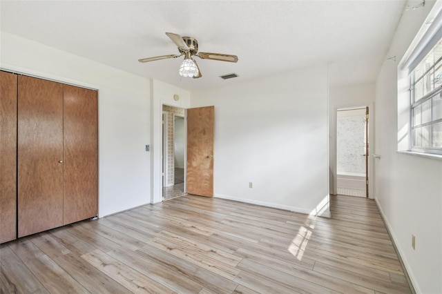 unfurnished bedroom featuring a closet, visible vents, a ceiling fan, light wood-type flooring, and baseboards