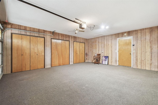 interior space with carpet floors and wooden walls