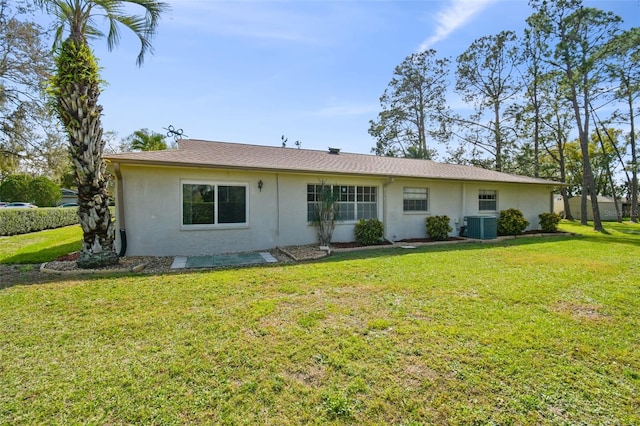 view of front of home featuring stucco siding, cooling unit, and a front yard