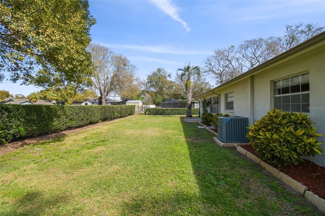 view of yard featuring fence and central air condition unit