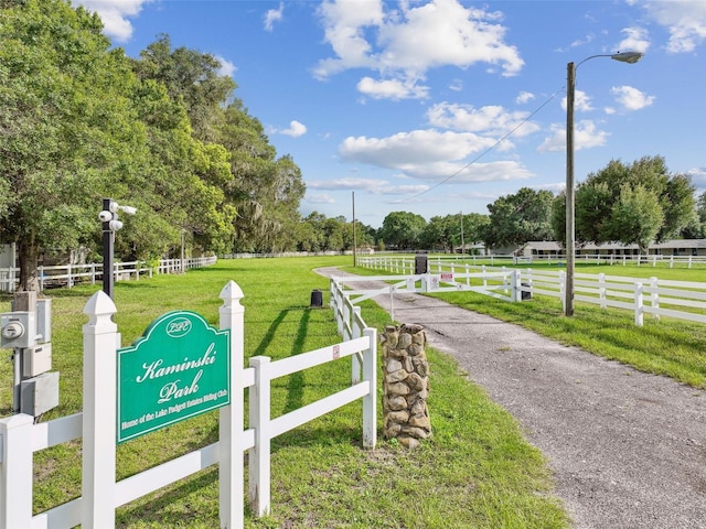 surrounding community with fence, a lawn, and a rural view