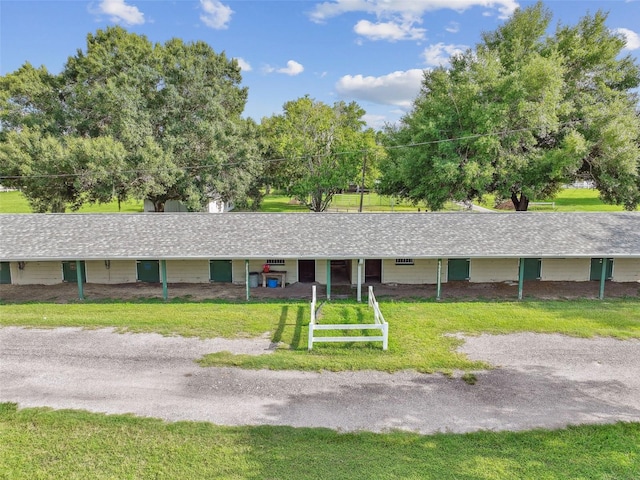 single story home with a shingled roof and a front yard