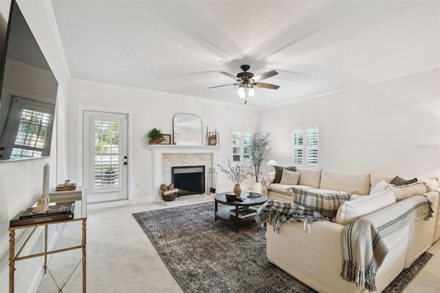 living room with light carpet, ceiling fan, a fireplace, and ornamental molding