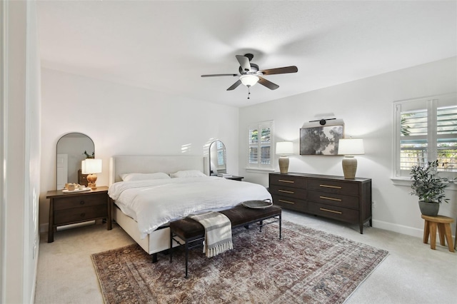 bedroom featuring light carpet, ceiling fan, and baseboards