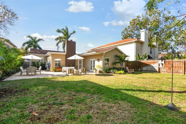 rear view of house with a patio area, a chimney, fence, and an outdoor hangout area