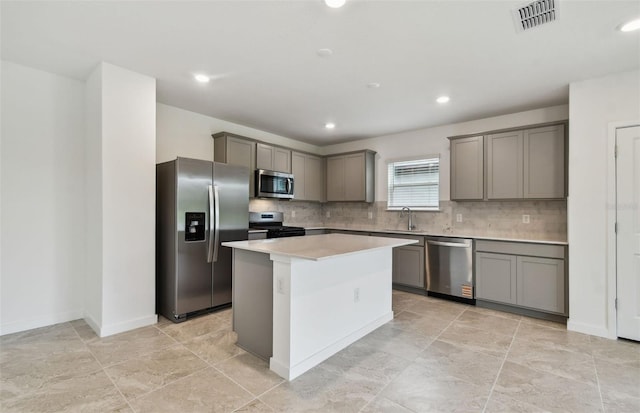 10410 Cross River Trl, Parrish, FL 34219 - kitchen featuring stainless steel appliances, gray cabinetry, a kitchen island, backsplash, and light countertops