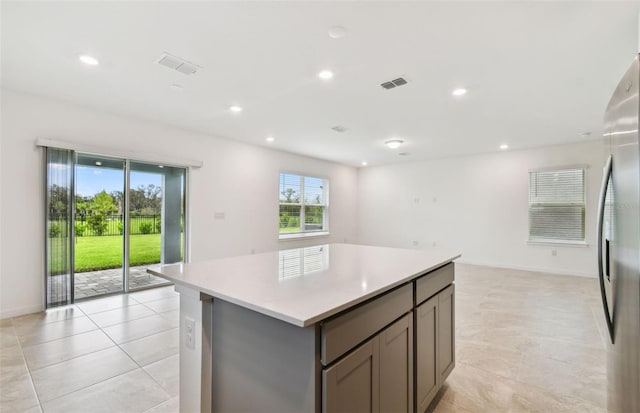 10410 Cross River Trl, Parrish, FL 34219 - kitchen with gray cabinetry, a center island, open floor plan, light countertops, and freestanding refrigerator