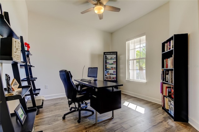 office space featuring a ceiling fan, baseboards, and wood finished floors