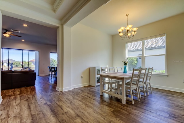 dining area with visible vents, baseboards, dark wood finished floors, crown molding, and ceiling fan with notable chandelier