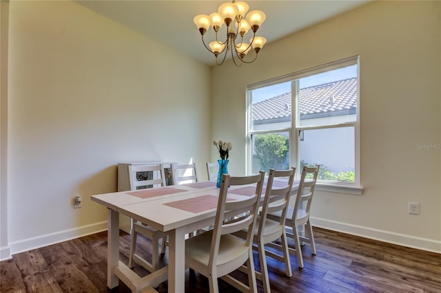 dining area featuring dark wood finished floors, a notable chandelier, and baseboards