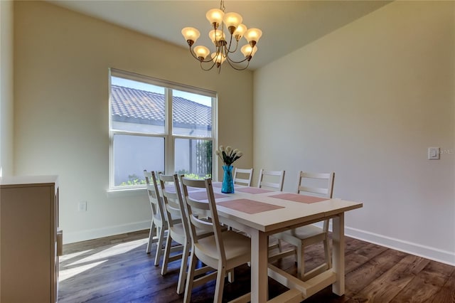 dining space featuring baseboards, dark wood-type flooring, and a notable chandelier