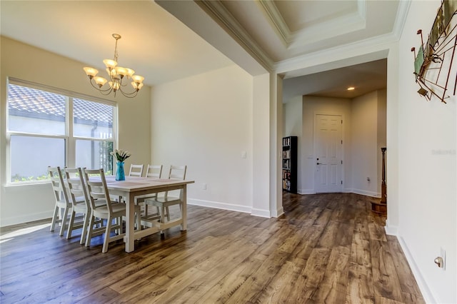 dining room with crown molding, dark wood-type flooring, baseboards, and a notable chandelier