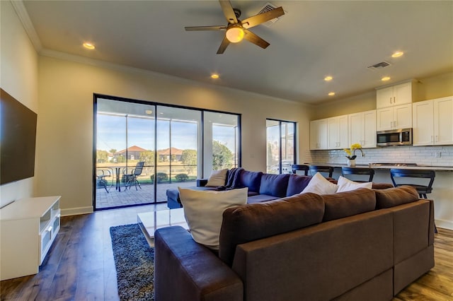 living area with ornamental molding, light wood finished floors, visible vents, and recessed lighting