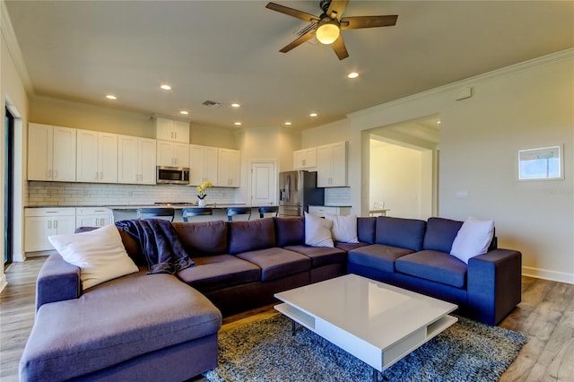 living area with ceiling fan, recessed lighting, baseboards, ornamental molding, and light wood-type flooring