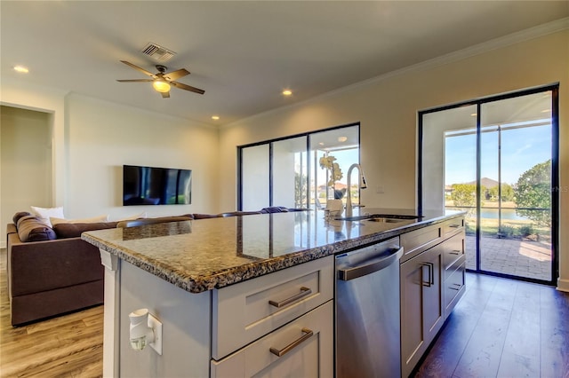 kitchen with visible vents, an island with sink, open floor plan, a sink, and stainless steel dishwasher