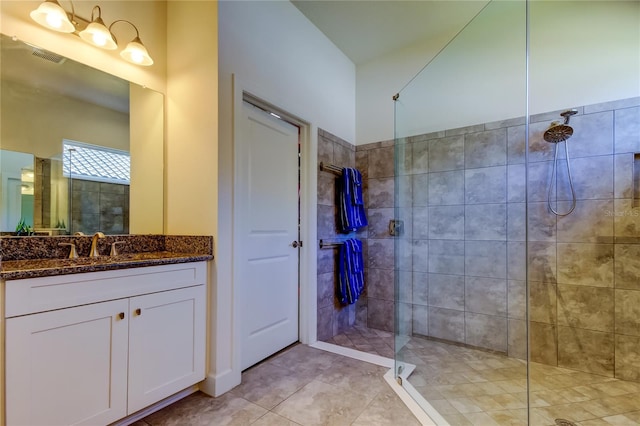 full bath featuring a walk in shower, visible vents, tile patterned flooring, and vanity