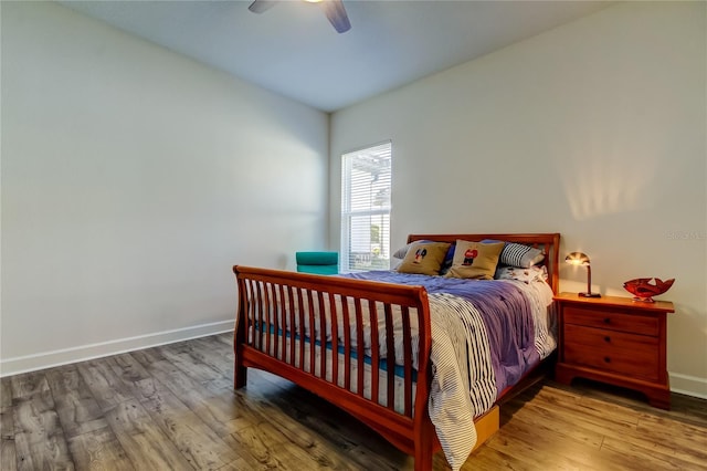 bedroom featuring wood finished floors, a ceiling fan, and baseboards