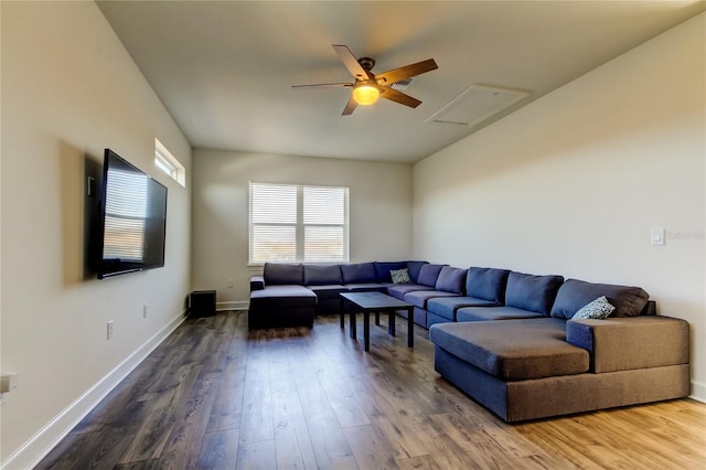 living room featuring a ceiling fan, attic access, baseboards, and wood finished floors