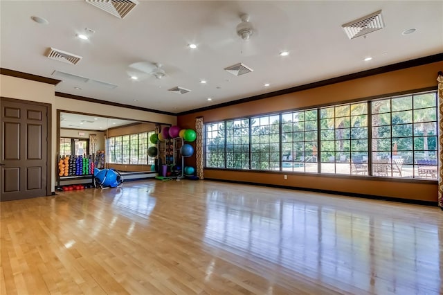 workout area with ornamental molding, visible vents, and a ceiling fan