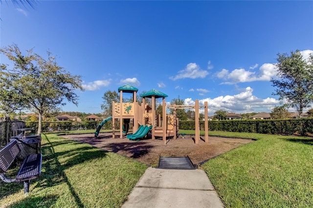 community jungle gym featuring a lawn and fence