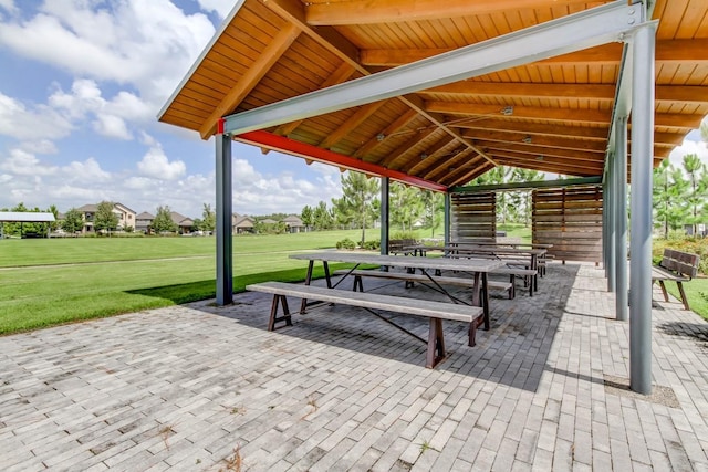 view of property's community with a patio area and a lawn