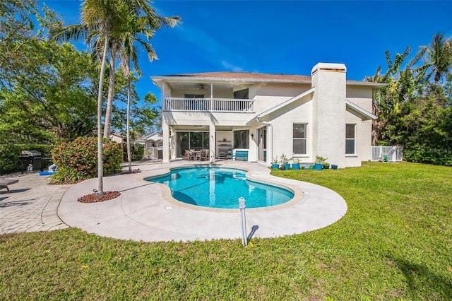 outdoor pool with a lawn and a patio area