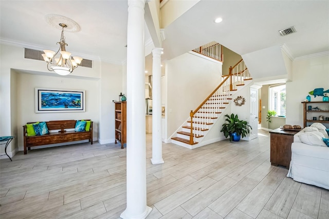 interior space featuring decorative columns, visible vents, ornamental molding, wood finished floors, and stairs