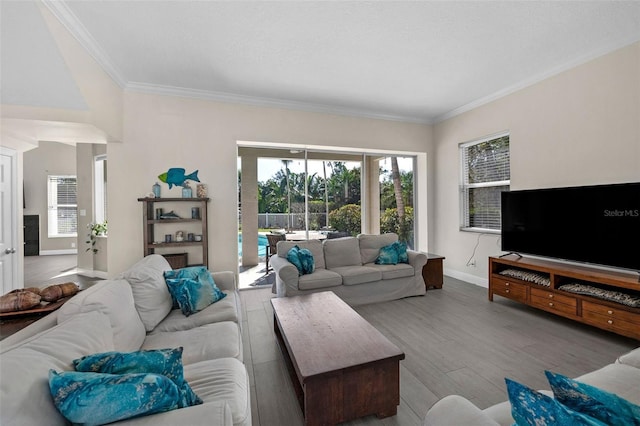 living area with ornamental molding, baseboards, and wood finished floors