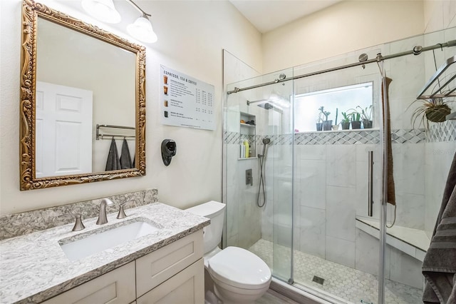 full bath featuring toilet, a stall shower, and vanity